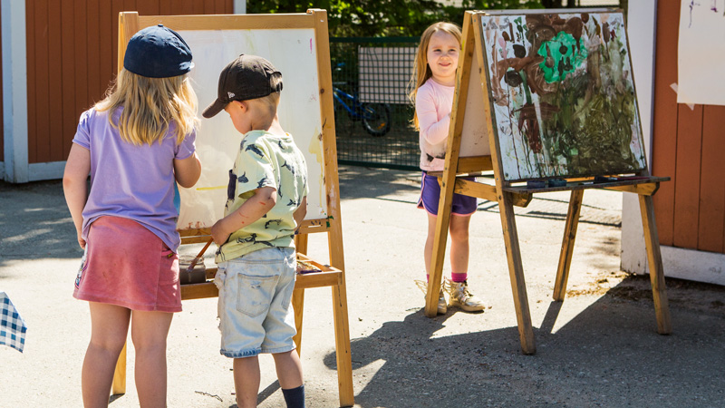 Barn målar utomhus.